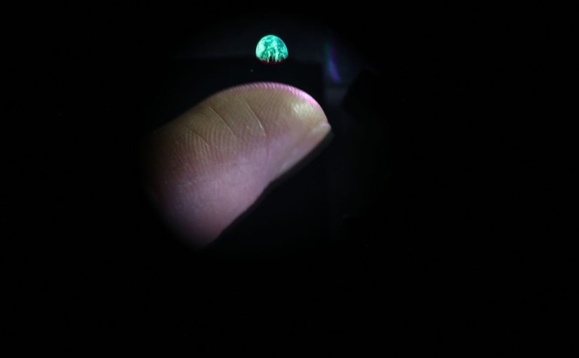3D image of earth volumetric display hovering above finger