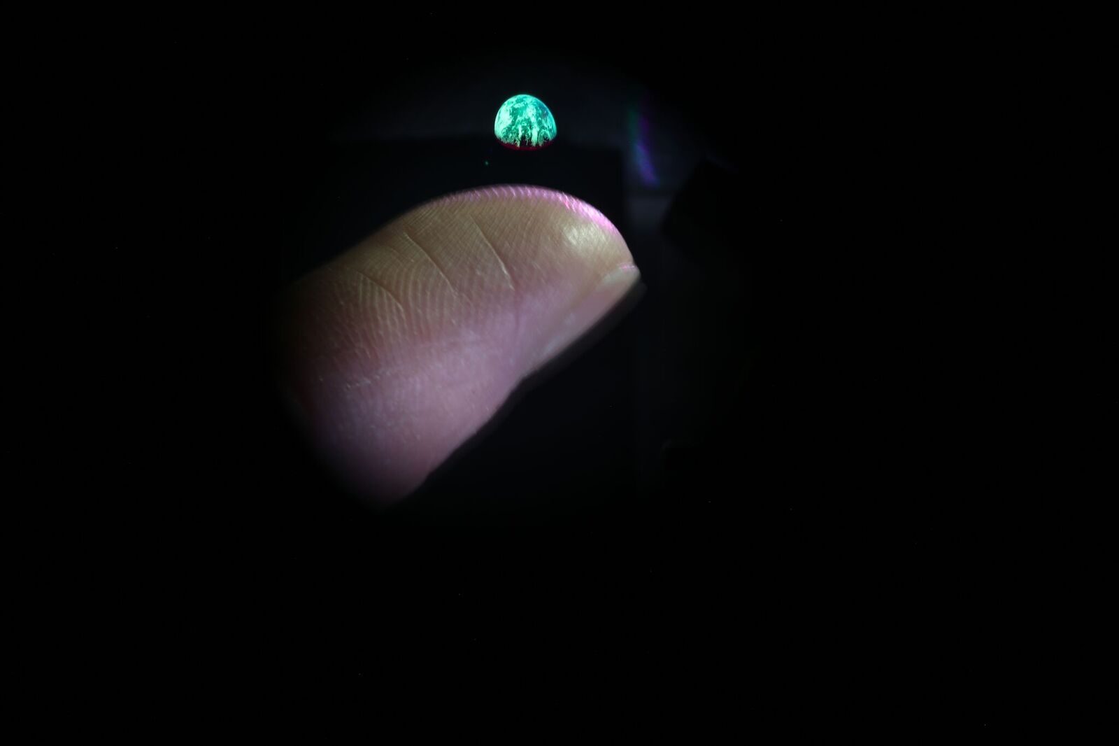 3D image of earth volumetric display hovering above finger